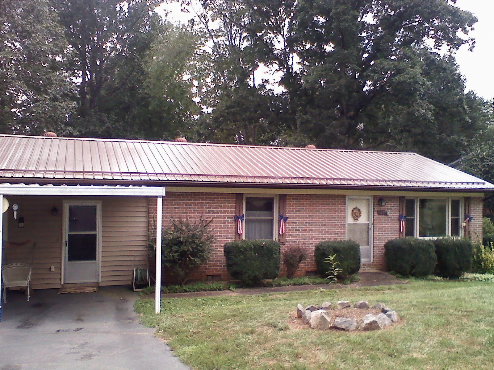 Bronze metal roof and carport on a brick ranch home — Roof Repair work by our crew in Gerlaw